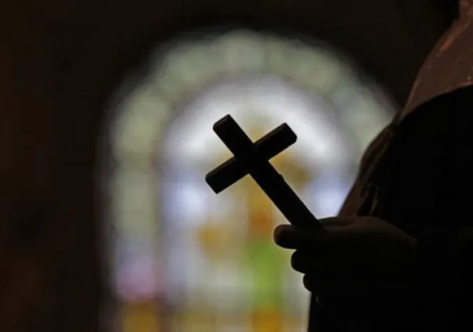 La silhouette d'un crucifix et un vitrail à l'intérieur d'une église catholique de la Nouvelle-Orléans. (image d'illustration) AP Photo/Keystone - Gerald Herbert