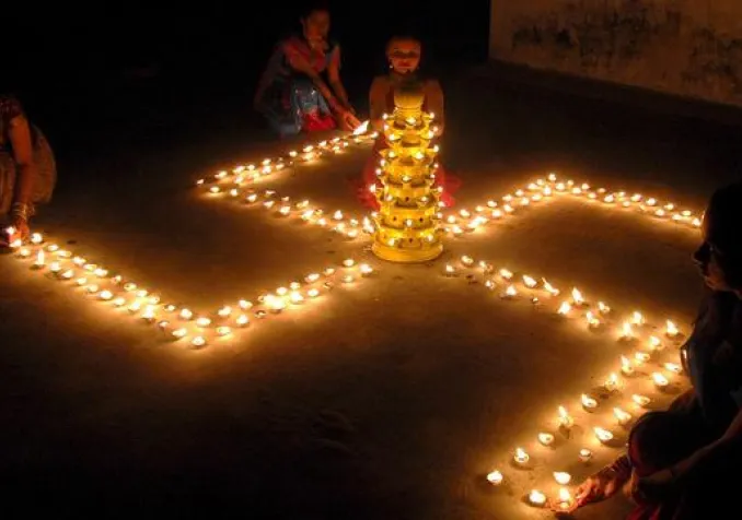 Une jeune femme formant une svastika avec des bougies lors d'un festival hindou, le 8 novembre 2007, en Inde. KEYSTONE - STR