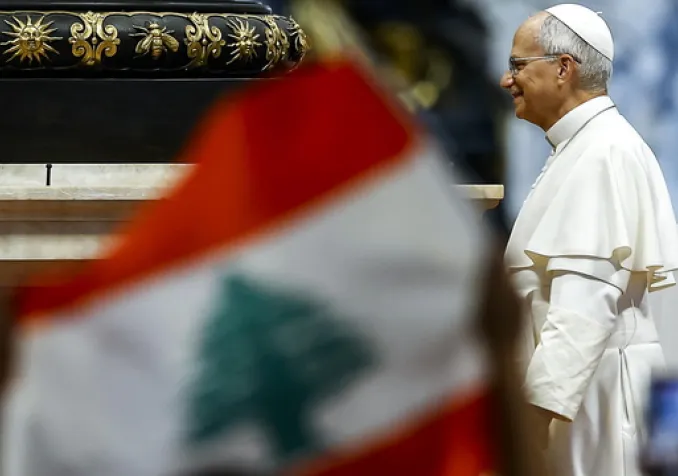 Un fidèle tient un drapeau libanais lors de l'arrivée du pape Léon XIV à l'audience générale hebdomadaire dans la basilique Saint-Pierre au Vatican, le 19 août 2026. KEYSTONE - ANGELO CARCONI