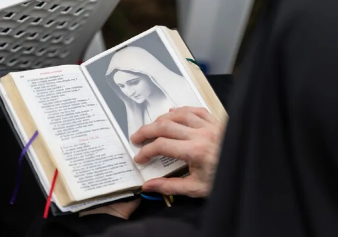 Un fidèle consulte une bible durant une messe. © KEYSTONE / CYRIL ZINGARO - CYRIL ZINGARO