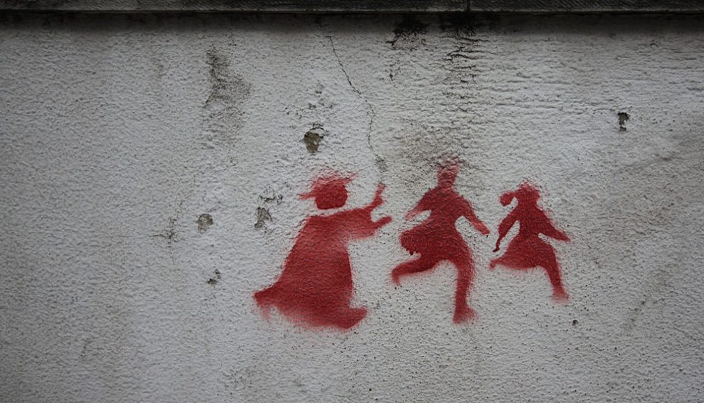 Graffiti sur un mur de Lisbonne montrant un prêtre pourchassant deux enfants. / © Wikimedia Commons/Milliped/CC-BY-3.0