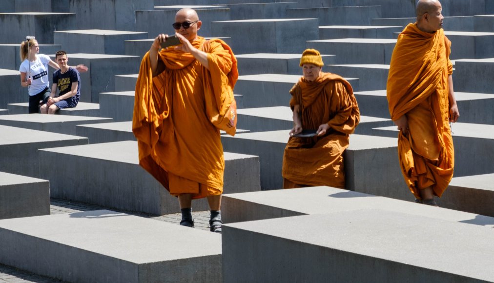 © Istock / hanohiki / Moines bouddhistes visitant le Mémorial de l’Holocauste à Berlin