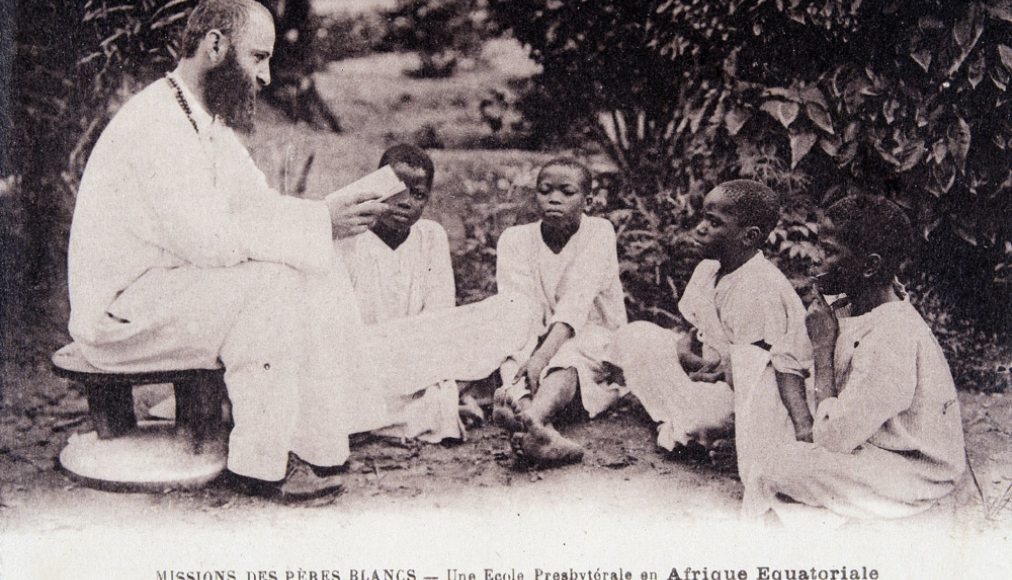 Missionnaire en Afrique : un membre de la société missionnaire des Pères Blancs enseignant à des enfants dans une école d&#039;Afrique équatoriale. Carte postale des années 1930 ©Collection Sirot-Angel/leemage / © Wikimedia Commons