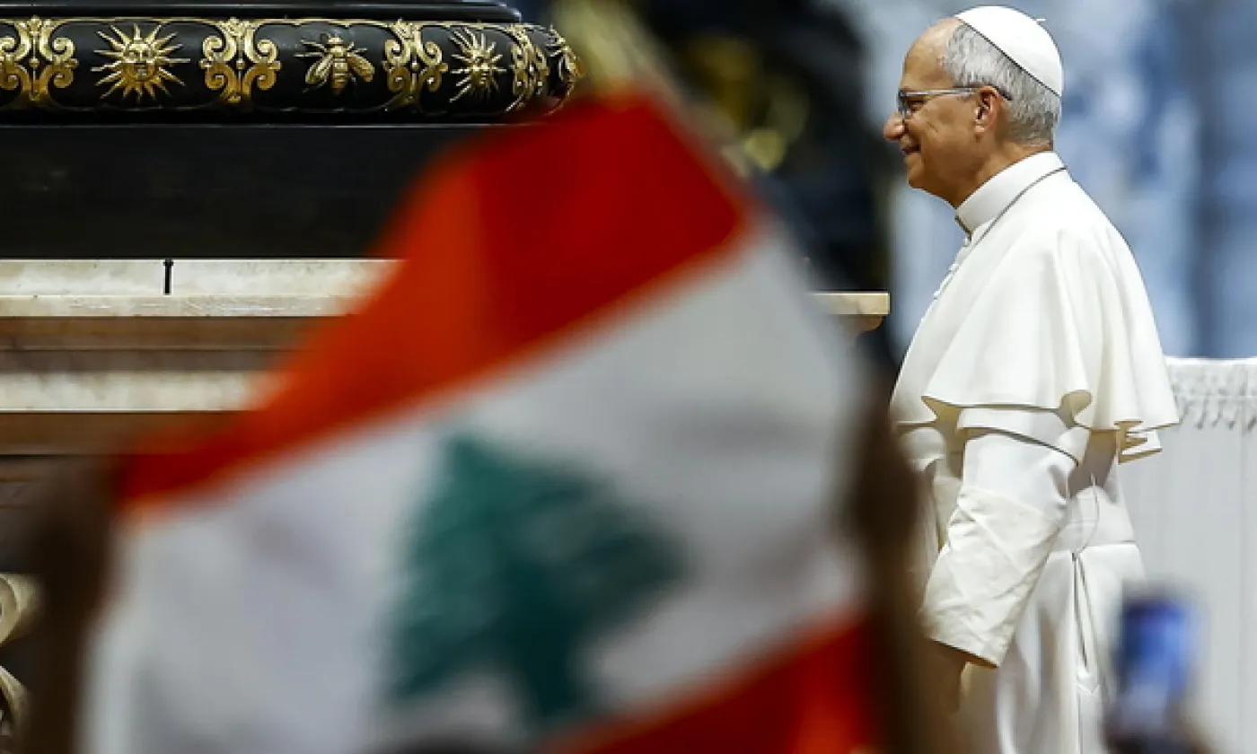 Un fidèle tient un drapeau libanais lors de l'arrivée du pape Léon XIV à l'audience générale hebdomadaire dans la basilique Saint-Pierre au Vatican, le 19 août 2026. KEYSTONE - ANGELO CARCONI