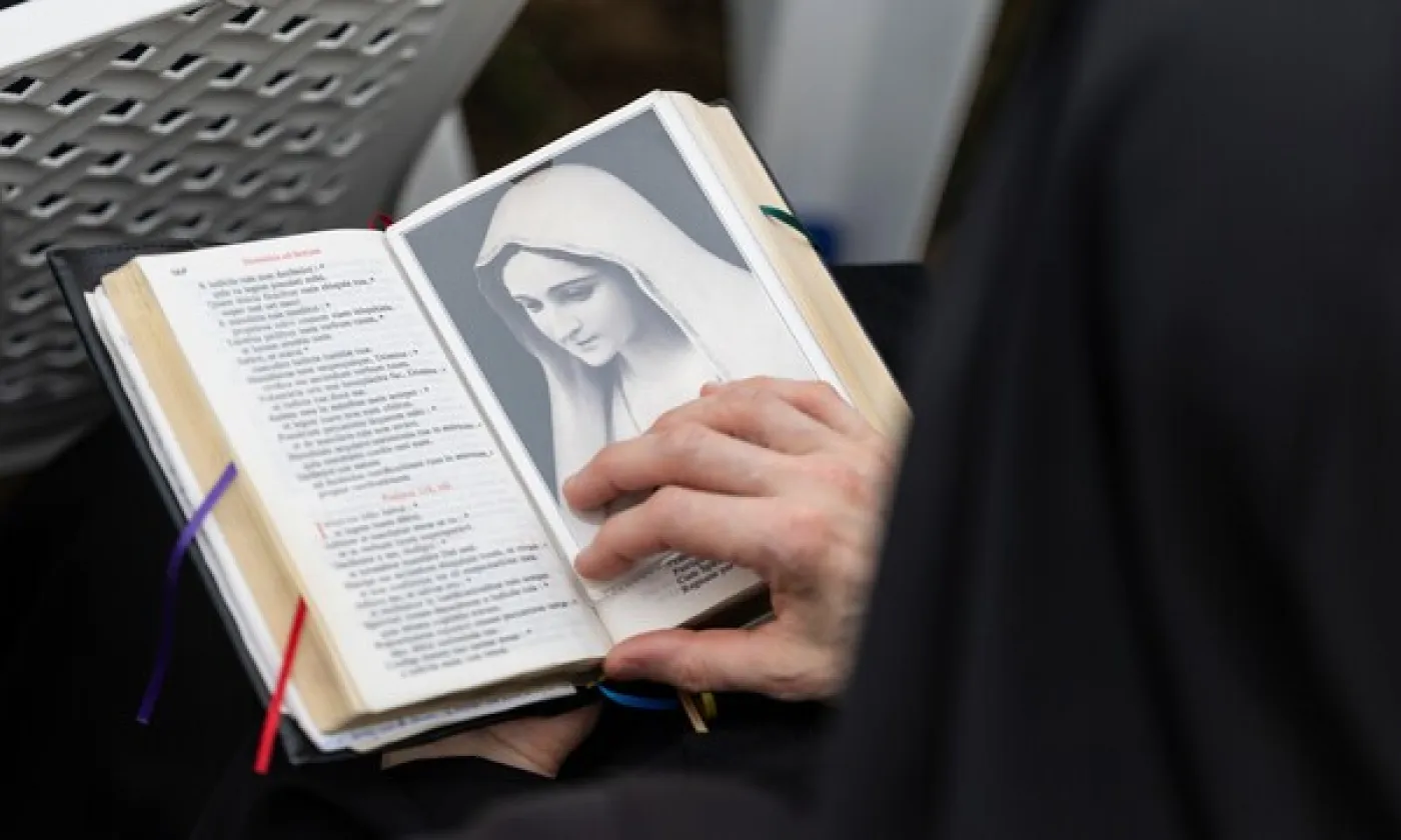 Un fidèle consulte une bible durant une messe. © KEYSTONE / CYRIL ZINGARO - CYRIL ZINGARO