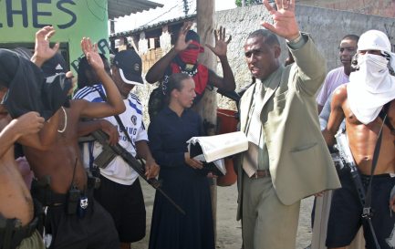 Sur cette photo prise le 31 mars 2009, le pasteur Andre Assis, au centre, prie avec des trafiquants de drogue présumés dans un bidonville de Rio de Janeiro. / Keystone
