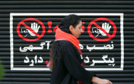 Le 10 août 2023. Une femme iranienne marche devant un magasin fermé de Téhéran, les cheveux au vent / Keystone